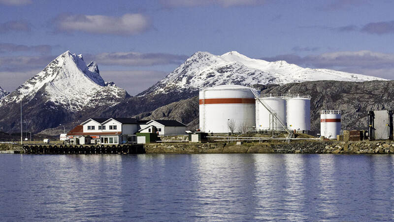 industrielle Anlage am Wasser vor Berghang