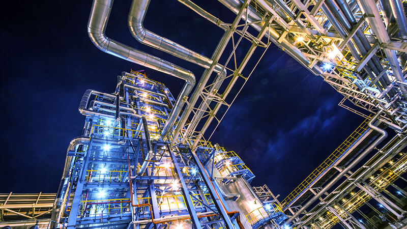 Rohrleitungen einer Industrieanlage bei Nacht
